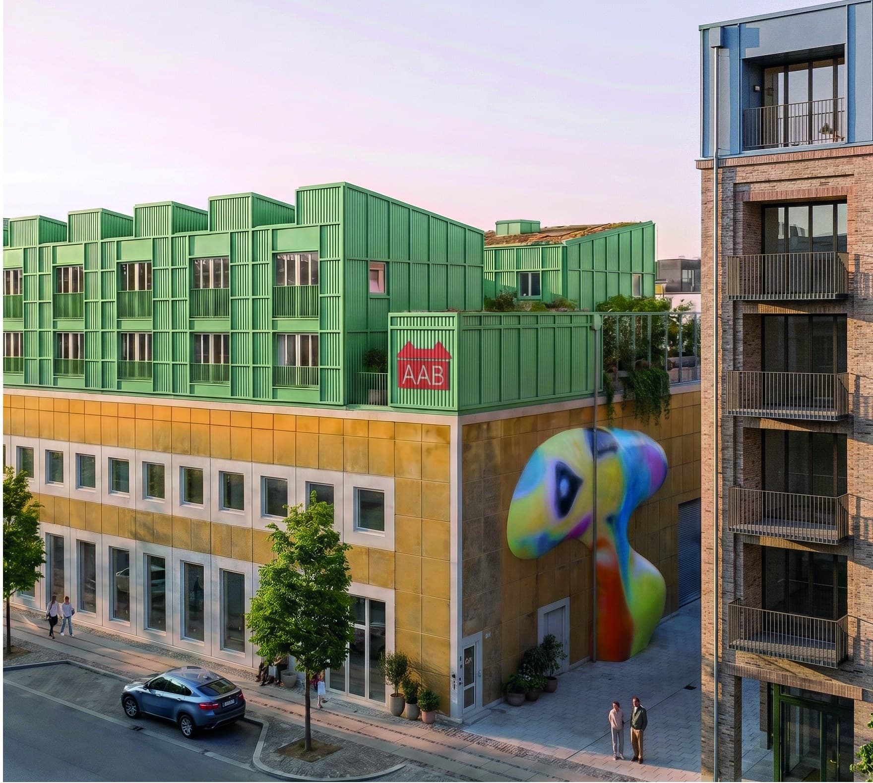 Visualisering af Prags Boulevard 55 i aftenlys: de nye tagboliger med grøn metalfacade over den gule bygning, med farverigt vægkunstværk på hjørnet